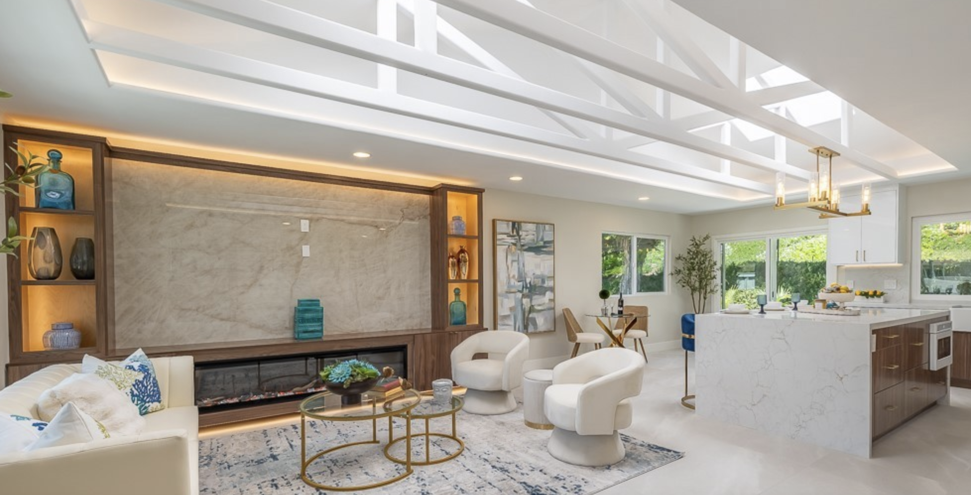 Great room with walnut built-ins, marble fireplace wall, and open-concept kitchen beyond