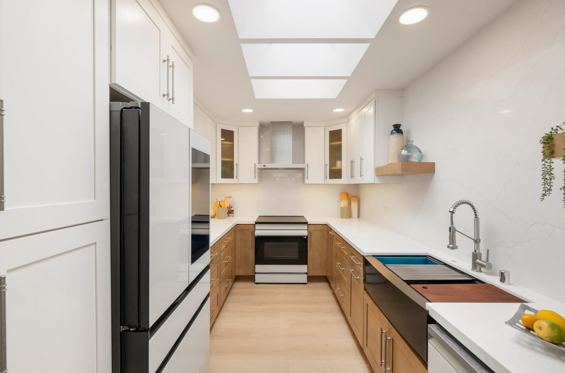 Galley kitchen remodel with skylights and two-tone cabinetry
