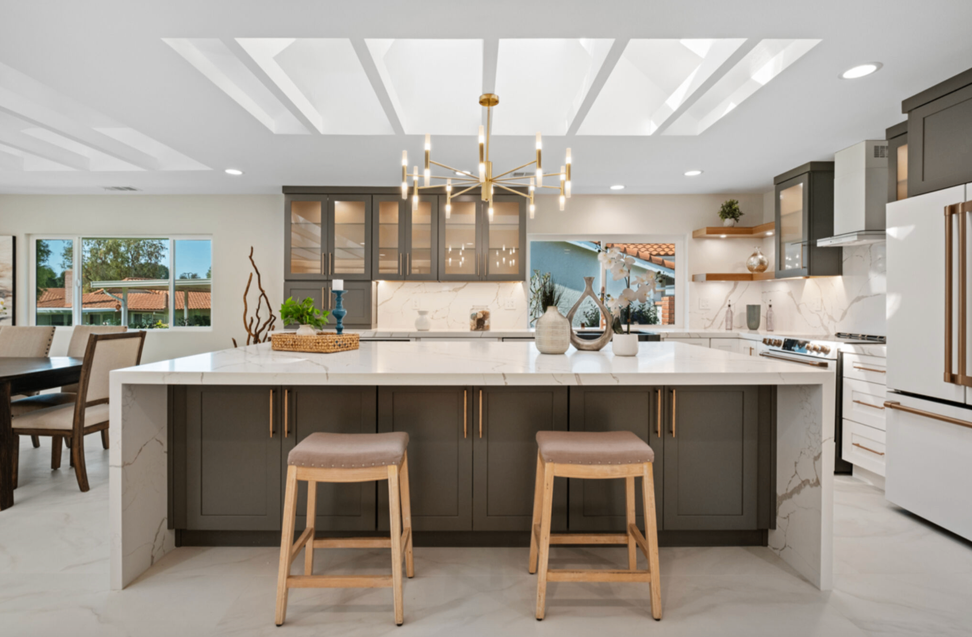 Luxury kitchen remodel with oversized waterfall island and statement chandelier by Rosewood Legacy Builders